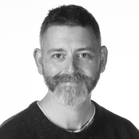 A man with a jumper and moustache.