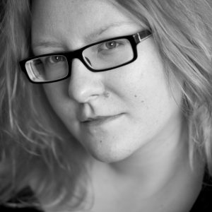 A woman with blonde hair and glasses.
