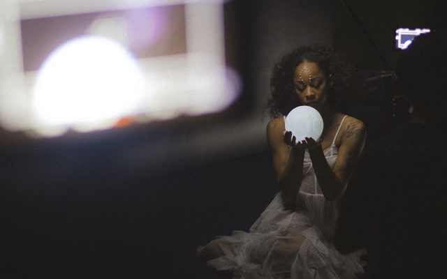 A woman looking at an orb.